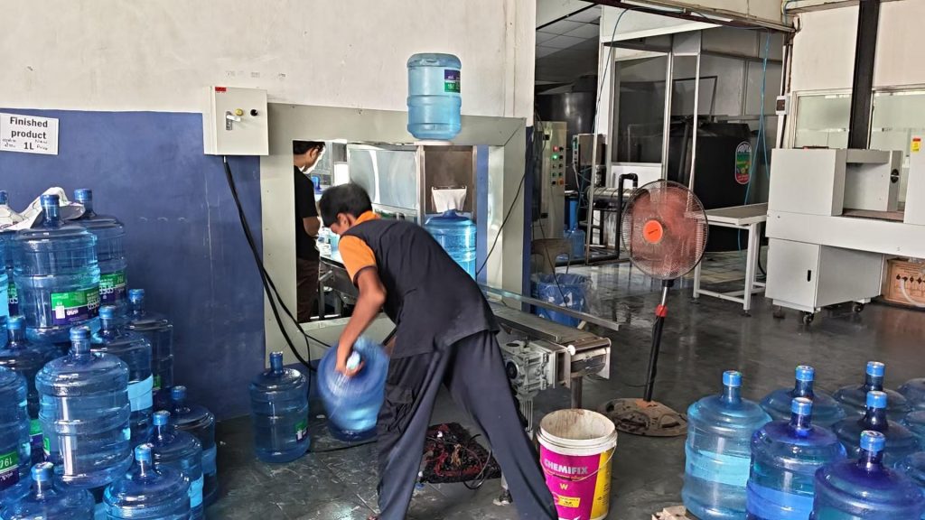 Workers are operating the 5 gallons water production line